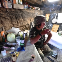 Ukrainian serviceman Andriy rests in a shelter on a position held by the Ukrainian army between southern cities of Mykolaiv and Kherson on Sunday. | AFP-JIJI
