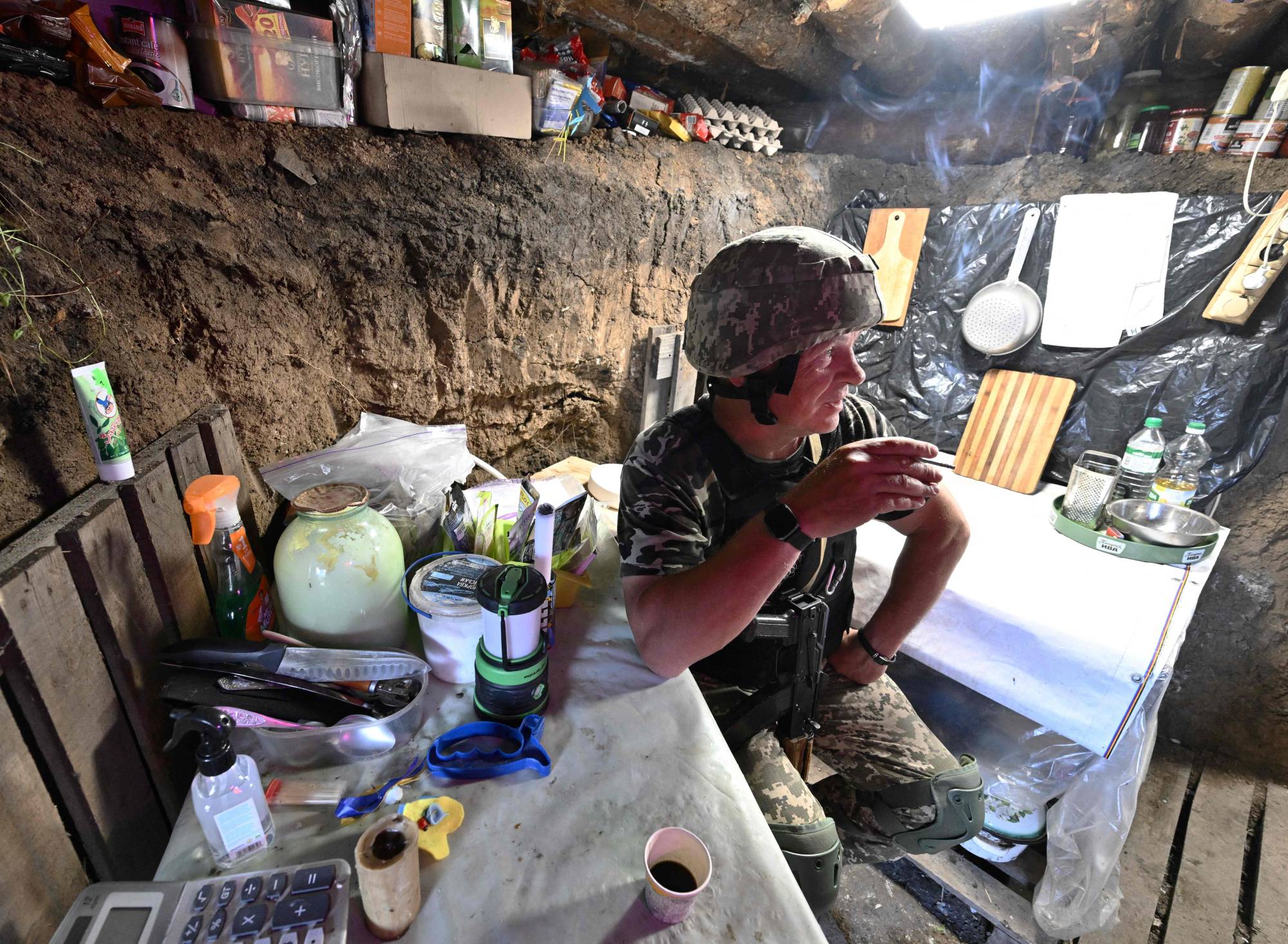 Ukrainian serviceman Andriy rests in a shelter on a position held by the Ukrainian army between southern cities of Mykolaiv and Kherson on Sunday. | AFP-JIJI
