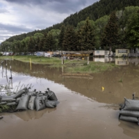 Floodwater breaches sandbags stacked by the roadside north of Yellowstone National Park on Tuesday. The most severely damaged northern section of the park may stay closed for the rest of the season.  | LOUISE JOHNS / THE NEW YORK TIMES
