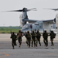 Ground Self-Defense Force personnel take part in a military demonstration in front of a V-22 Osprey during the Pacific Amphibious Leaders Symposium 2022 at a base in Kisarazu, east of Tokyo, on Thursday. | REUTERS