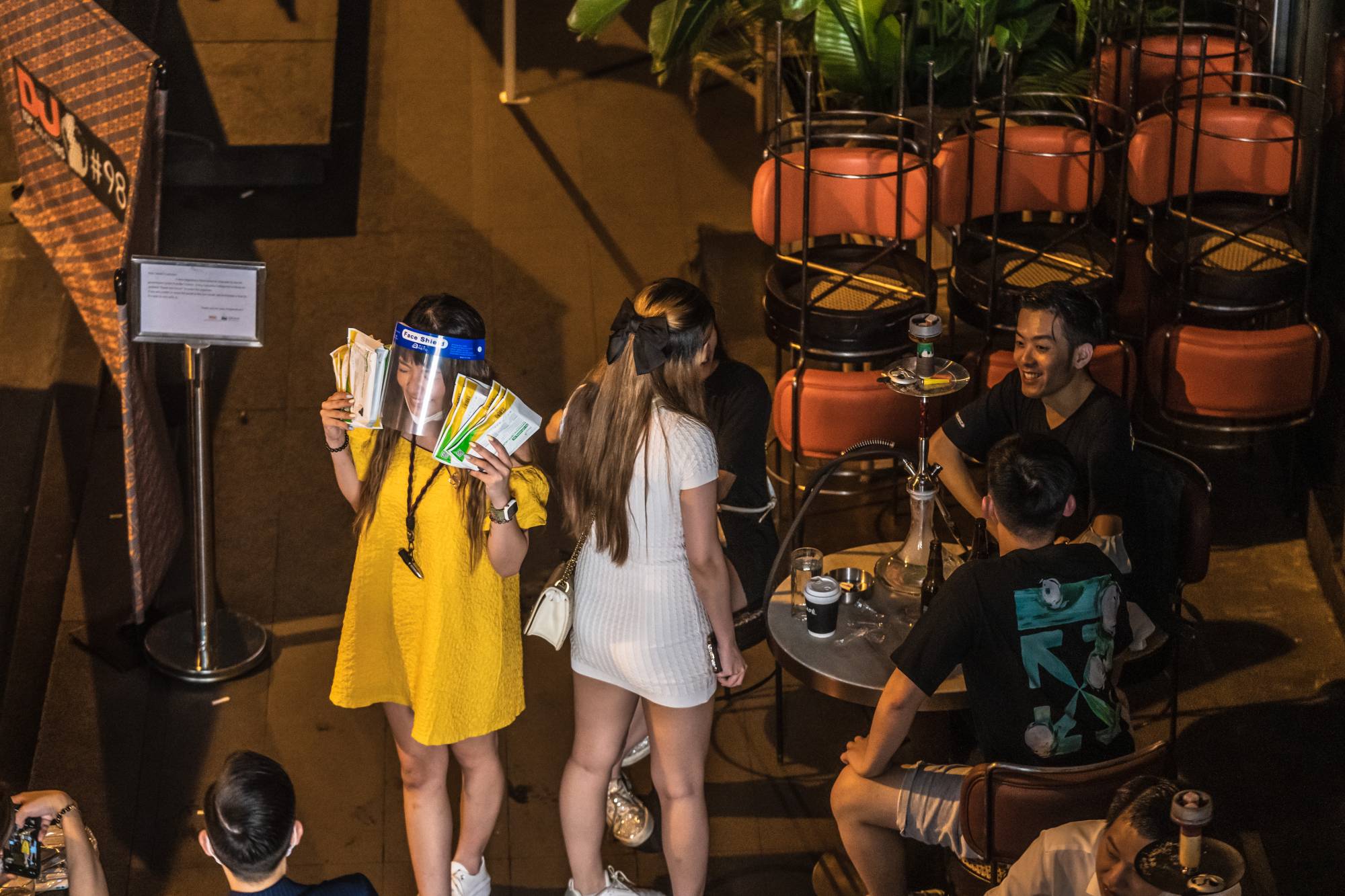 A customer holds packs of COVID-19 rapid antigen tests at a bar at the Lan Kwai Fong nightlife area in Hong Kong on Thursday. | Bloomberg