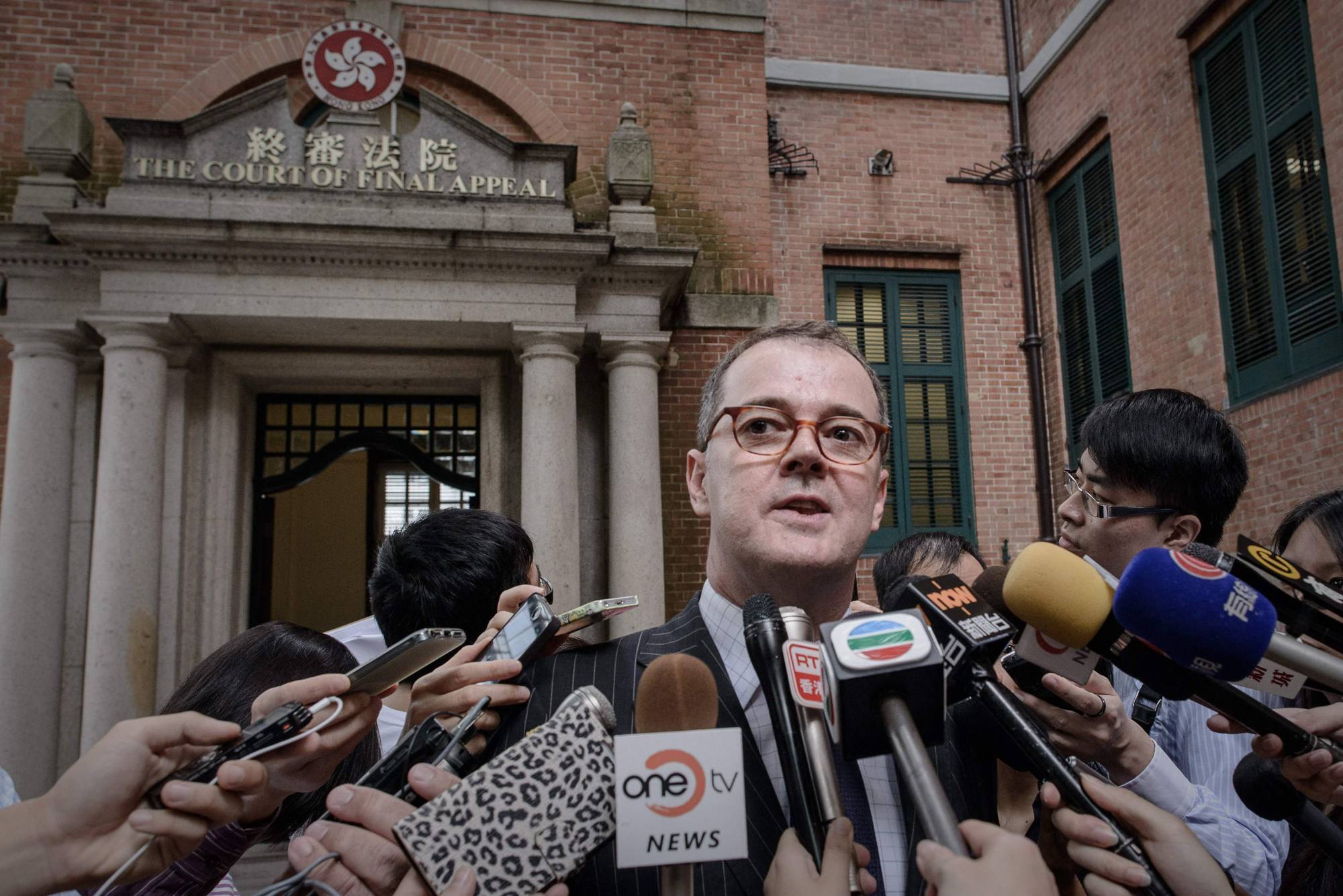 British human rights lawyer Michael Vidler speaks to reporters outside a Hong Kong courthouse in 2013. Vidler left Hong Kong in May, after almost two decades working in the former British colony, and closed his law firm shortly after amid growing concern that the rule of law is becoming more influenced by the mainland. | AFP-JIJI