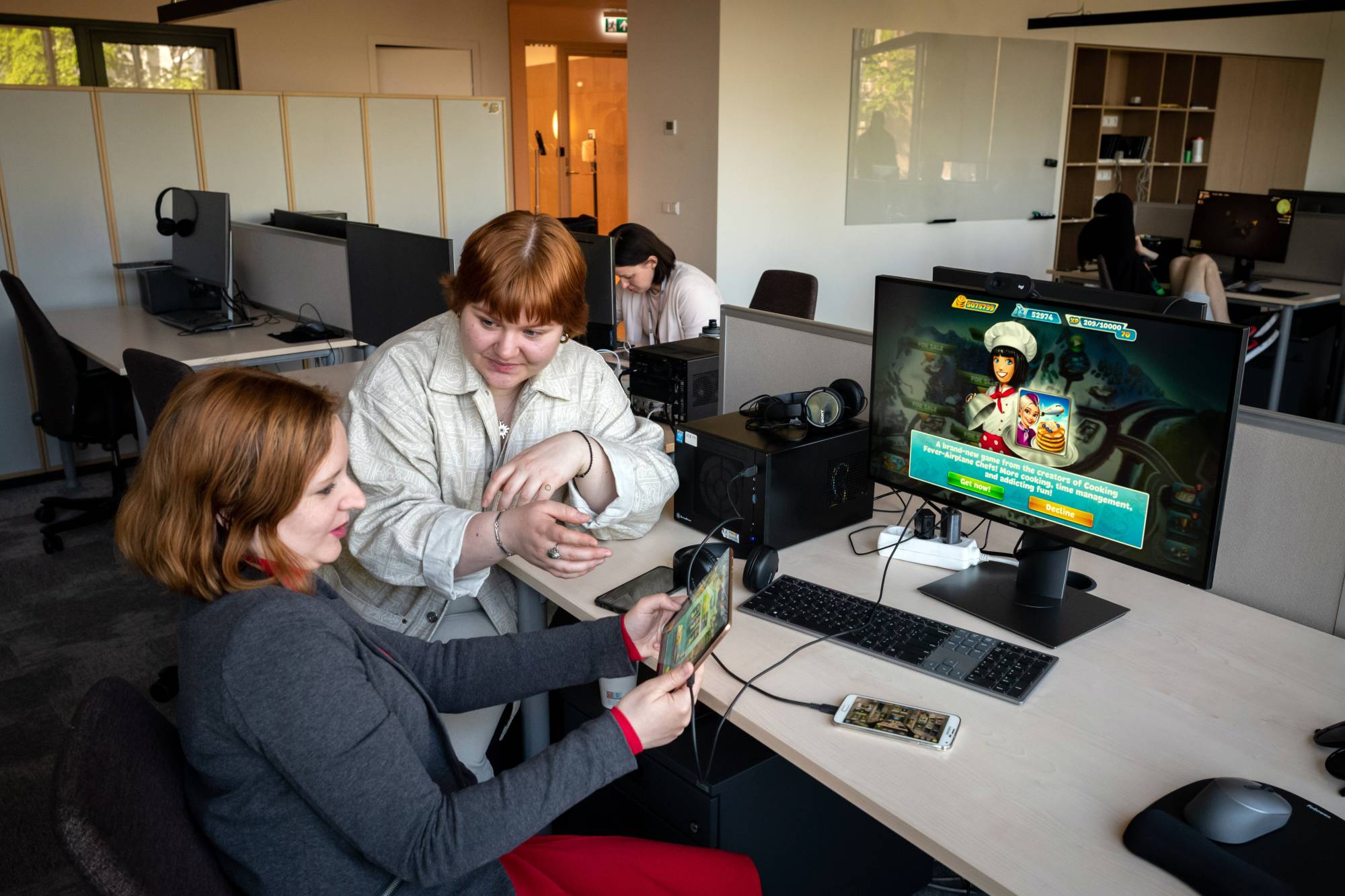 Inha Kushnir (left) and Nastya Dahno working at the headquarters of the game-maker Nordcurrent in Vilnius, Lithuania, on May 23. They were among the employees in Ukraine that were evacuated by the company as Russia invaded. | Gordon Welters / The New York Times
