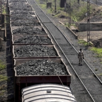 A freight train laden with coal stands on the tracks in Odisha, India. Nippon Steel may invest more in coal mines after the energy source surged in price. | BLOOMBERG