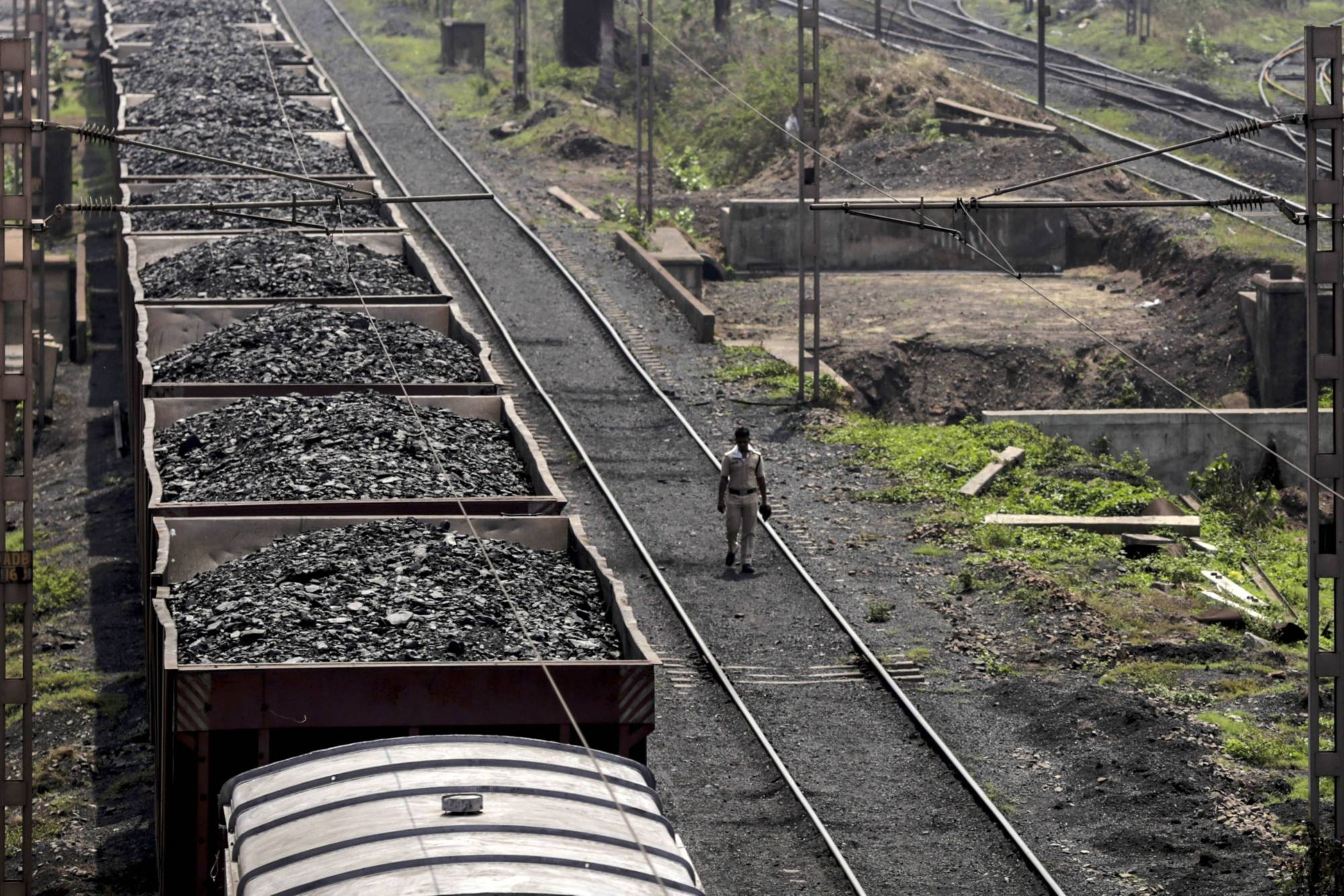 A freight train laden with coal stands on the tracks in Odisha, India. Nippon Steel may invest more in coal mines after the energy source surged in price. | BLOOMBERG