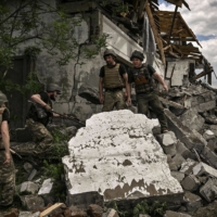 Ukrainian soldiers inspect a destroyed warehouse reportedly targeted by Russian troops on outskirts of Lysychansk, in the eastern Ukrainian region of Donbas on Friday.  | GETTY IMAGES / VIA AFP-JIJI