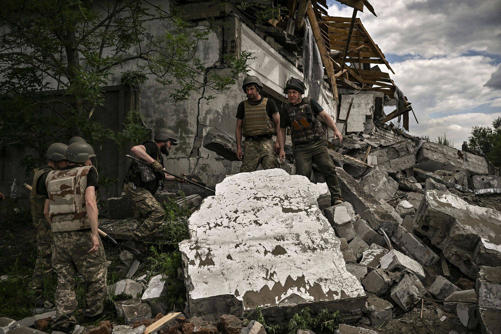 Ukrainian soldiers inspect a destroyed warehouse reportedly targeted by Russian troops on outskirts of Lysychansk, in the eastern Ukrainian region of Donbas on Friday. | Getty Images / via AFP-JIJI
