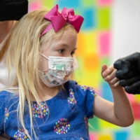 Emelia Glenn, 3, gives a fist bump after receiving the Moderna COVID-19 vaccine at Skippack Pharmacy in Schwenksville, Pennsylvania, on Monday. | REUTERS