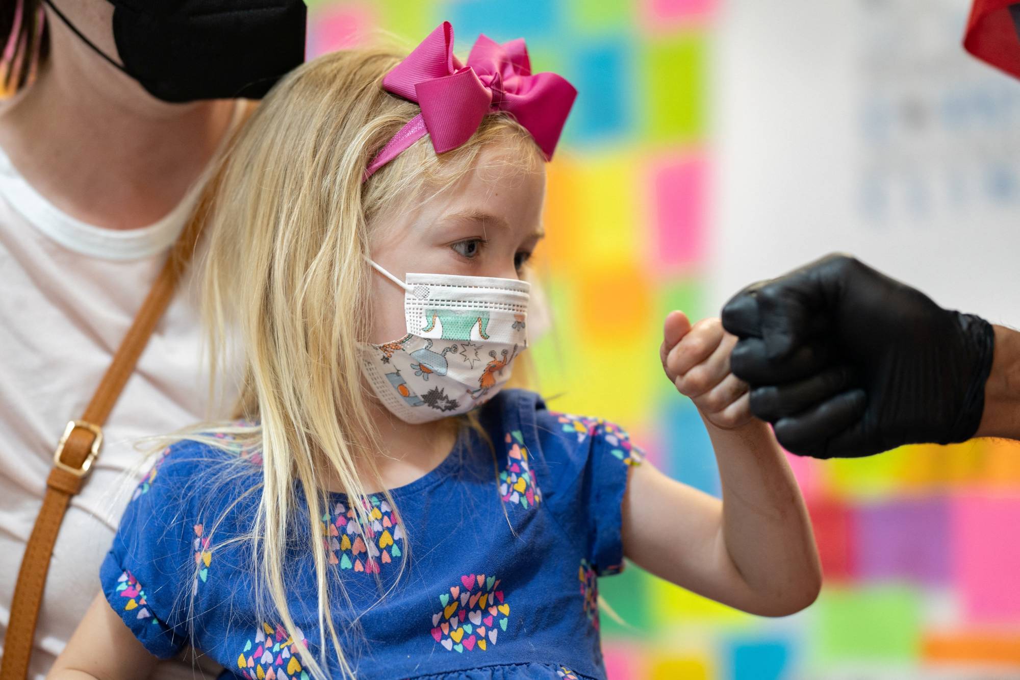 Emelia Glenn, 3, gives a fist bump after receiving the Moderna COVID-19 vaccine at Skippack Pharmacy in Schwenksville, Pennsylvania, on Monday. | REUTERS
