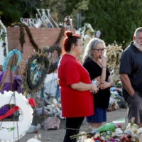 Ricca Amaro and her parents, Alma and Ramon Amaro, all from San Antonio, visit the memorial for the shooting victims at Robb Elementary School early Saturday morning in Uvalde, Texas, on June 11. | REUTERS
