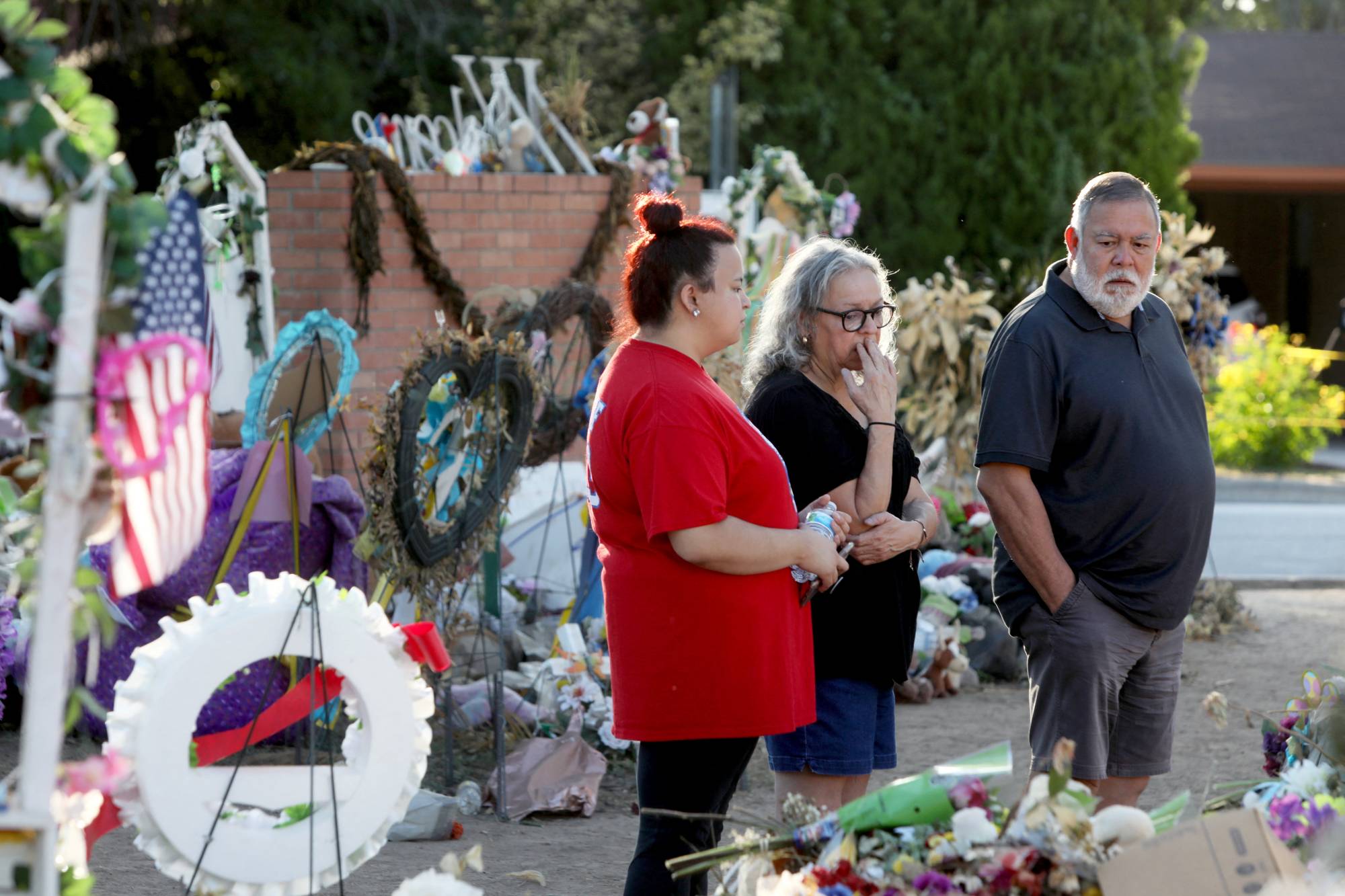 Ricca Amaro and her parents, Alma and Ramon Amaro, all from San Antonio, visit the memorial for the shooting victims at Robb Elementary School early Saturday morning in Uvalde, Texas, on June 11. | REUTERS