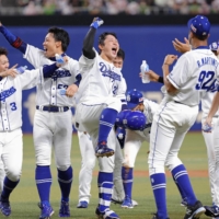 The Dragons celebrate Taiki Mitsumata\'s walk-off single against the Swallows in Nagoya on Tuesday. | KYODO