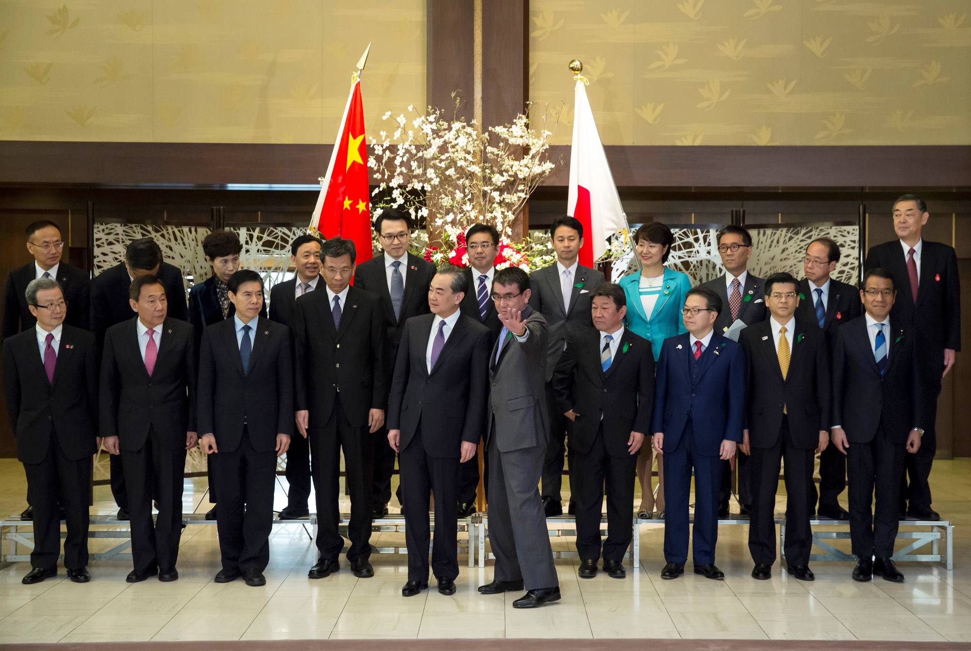 Wang Yi, China's foreign minister, and Taro Kono, then-Japan's foreign minister, are seen with their countries' economy ministers and other officials ahead of a high-level China-Japan economic dialogue in Tokyo in April 2018. | POOL / VIA REUTERS
