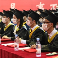 Graduating students wearing face masks attend a commencement ceremony at Chongqing University of Posts and Telecommunications in Chongqing, China, on Wednesday. | CNSPHOTO / VIA REUTERS 