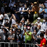 Voters listen to a speech during the Upper House election campaign amid hot weather in Kawasaki on Friday. | REUTERS