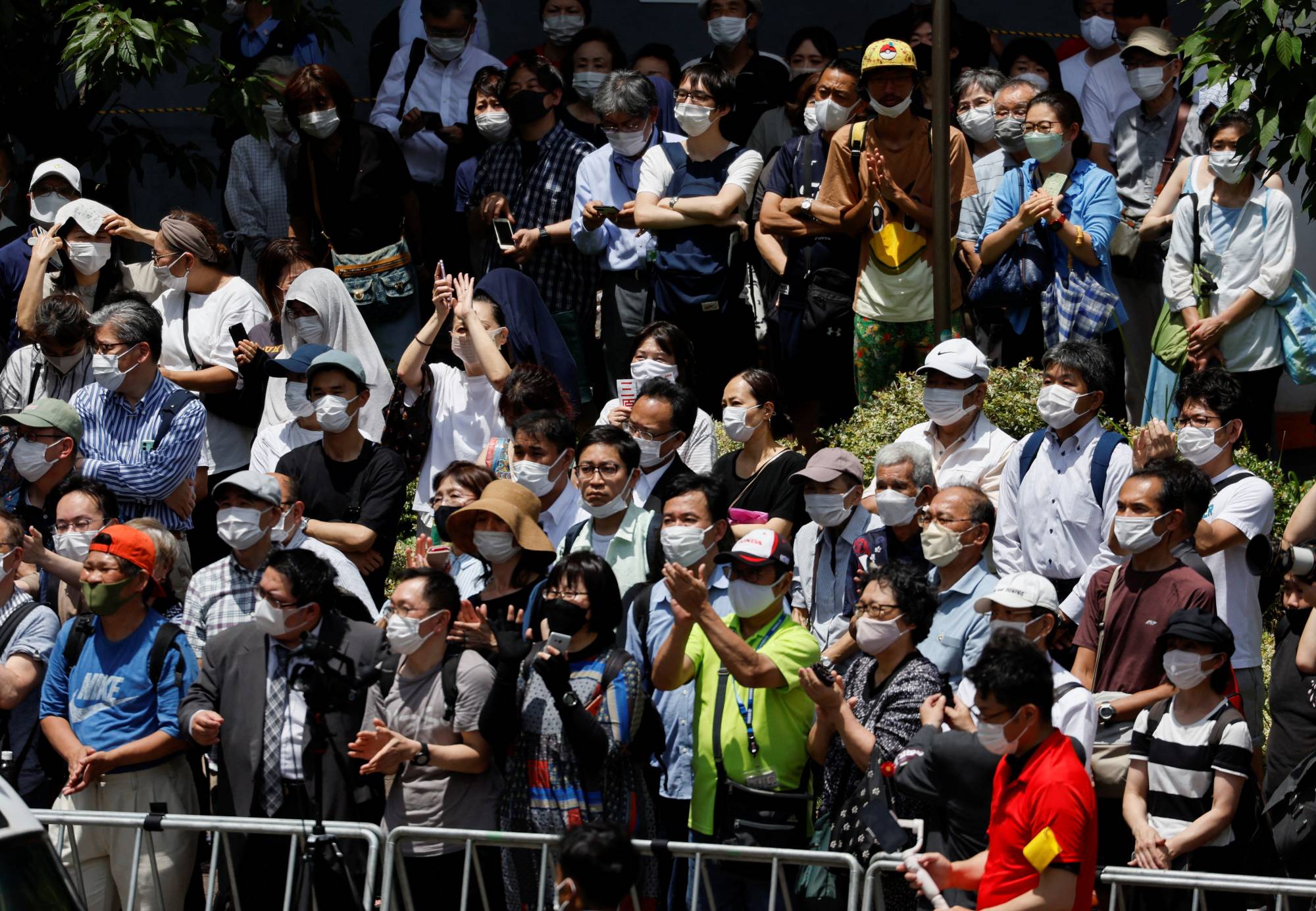 Voters listen to a speech during the Upper House election campaign amid hot weather in Kawasaki on Friday. | REUTERS