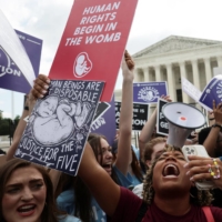 Anti-abortion demonstrators celebrate outside the United States Supreme Court in Washington on Friday. | REUTERS 