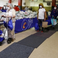 People line up to receive food donations at a food bank at a church in Queens, New York, in May 2020 during the early days of the COVID-19 outbreak. | REUTERS