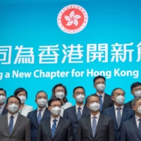 Incoming Hong Kong leader John Lee (front row center) with his Cabinet. Lee hasn’t articulated how Hong Kong can open to the world while also seeking to meet Beijing’s strict conditions for opening the land border with the mainland. | BLOOMBERG 