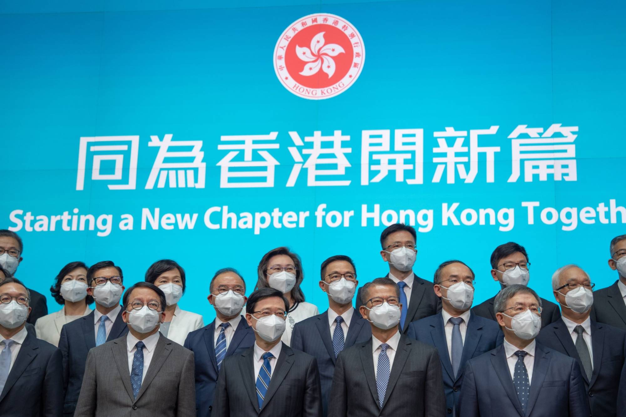 Incoming Hong Kong leader John Lee (front row center) with his Cabinet. Lee hasn’t articulated how Hong Kong can open to the world while also seeking to meet Beijing’s strict conditions for opening the land border with the mainland. | Bloomberg 