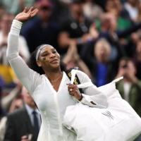 Serena Williams waves to the crowd after her Wimbledon first-round defeat to Harmony Tan in London on Tuesday. | REUTERS