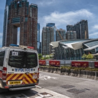 Police vehicles outside the West Kowloon Station in Hong Kong on Monday | BLOOMBERG