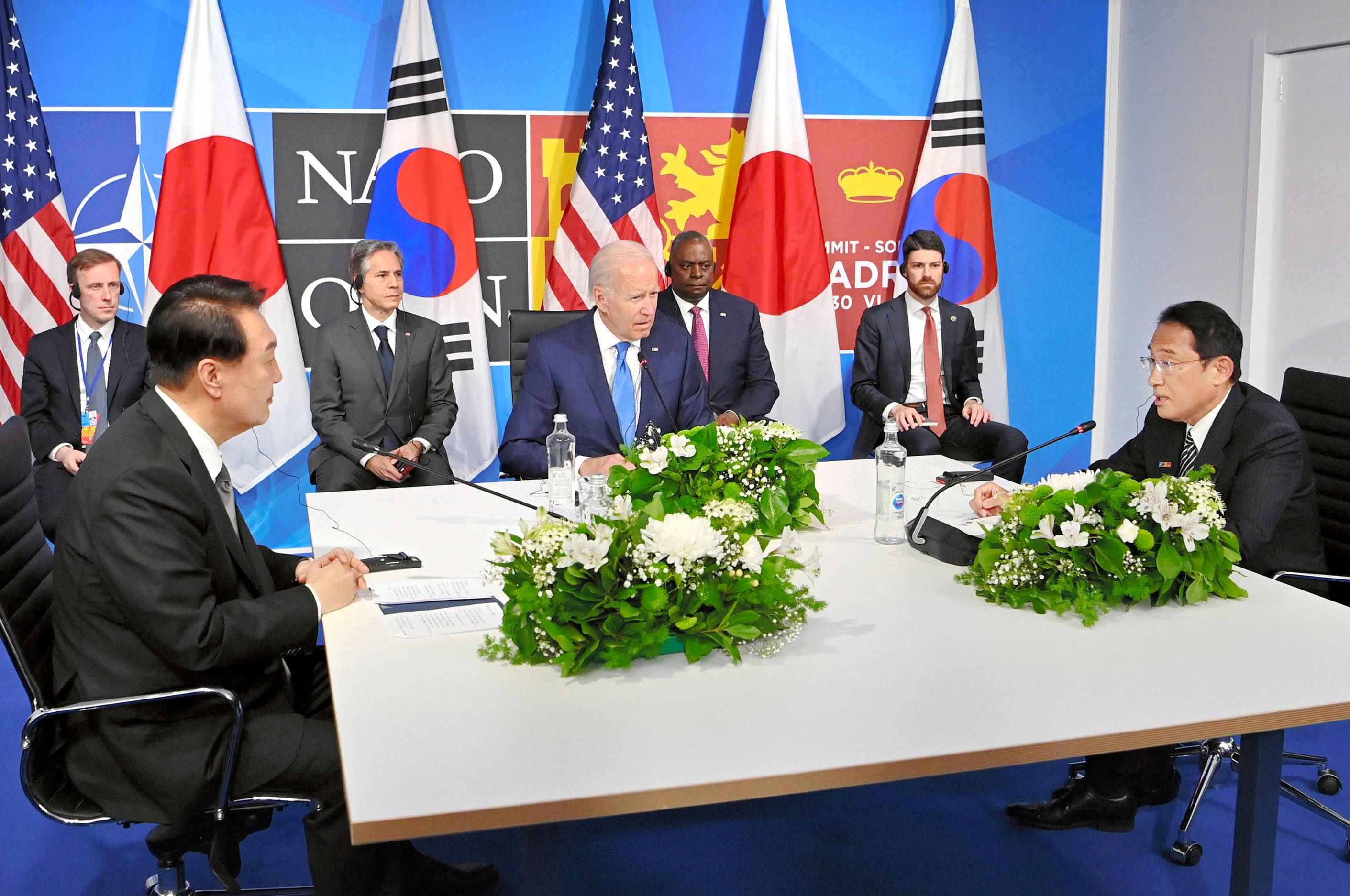 Prime Minister Fumio Kishida (right) speaks at the outset of his meeting with U.S. President Joe Biden and South Korean President Yoon Suk-yeol in Madrid on Wednesday. | POOL / VIA KYODO