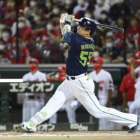 The Swallows\' Munetaka Murakami hits a two-run home run against the Carp during the ninth inning in Hiroshima on Wednesday. | KYODO