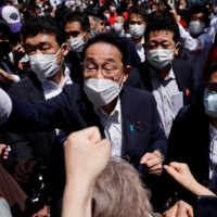 Prime Minister Fumio Kishida bumps fists with voters after delivering a speech on June 24. | REUTERS