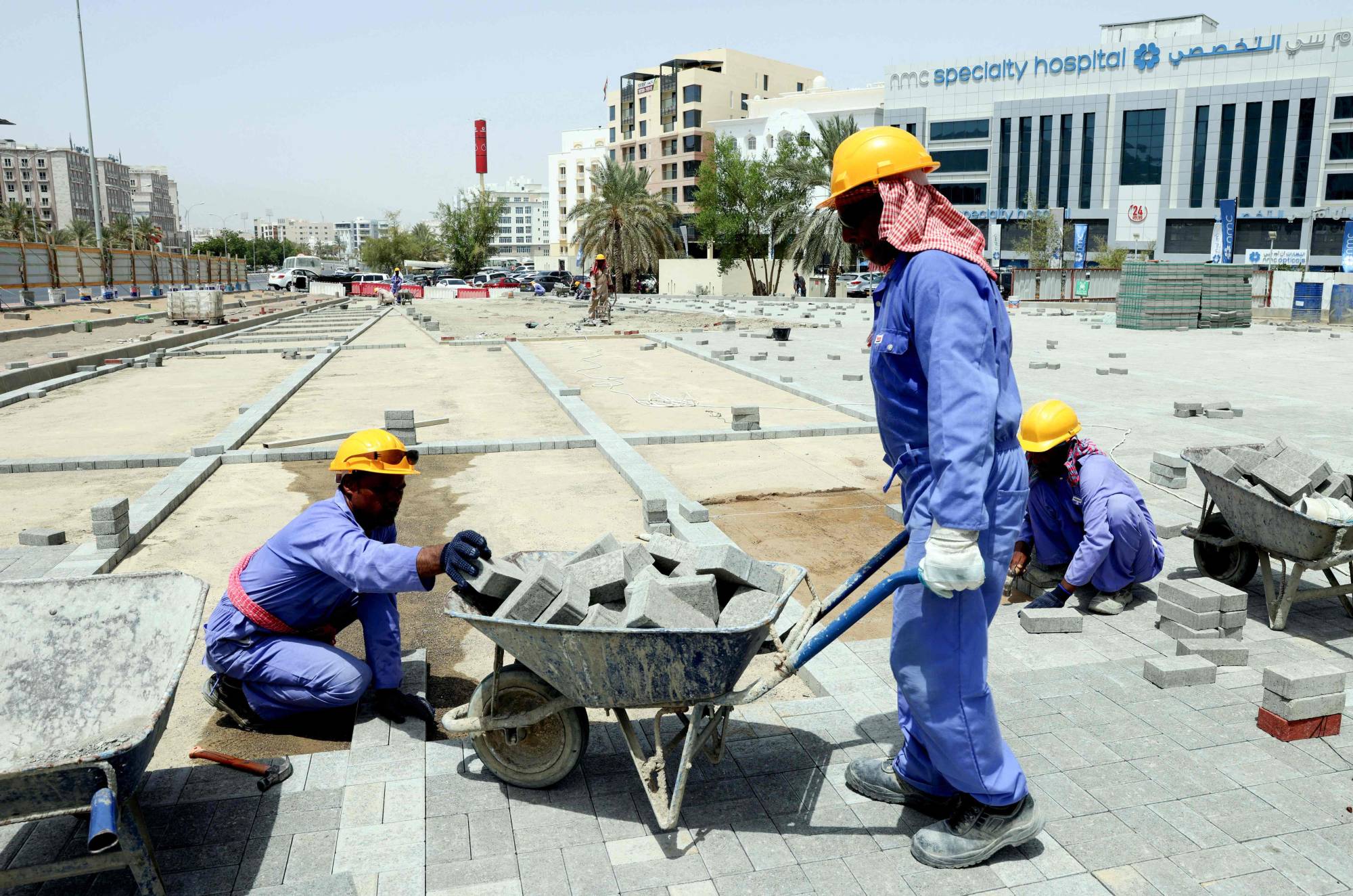 Foreign workers at a construction site in Muscat on June 21 | AFP-Jiji