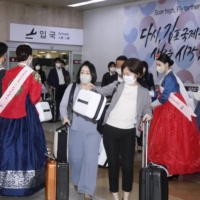 Passengers are welcomed at Seoul\'s Gimpo Airport after arriving via a freshly resumed flight from Haneda Airport in Tokyo on Wednesday. | KYODO