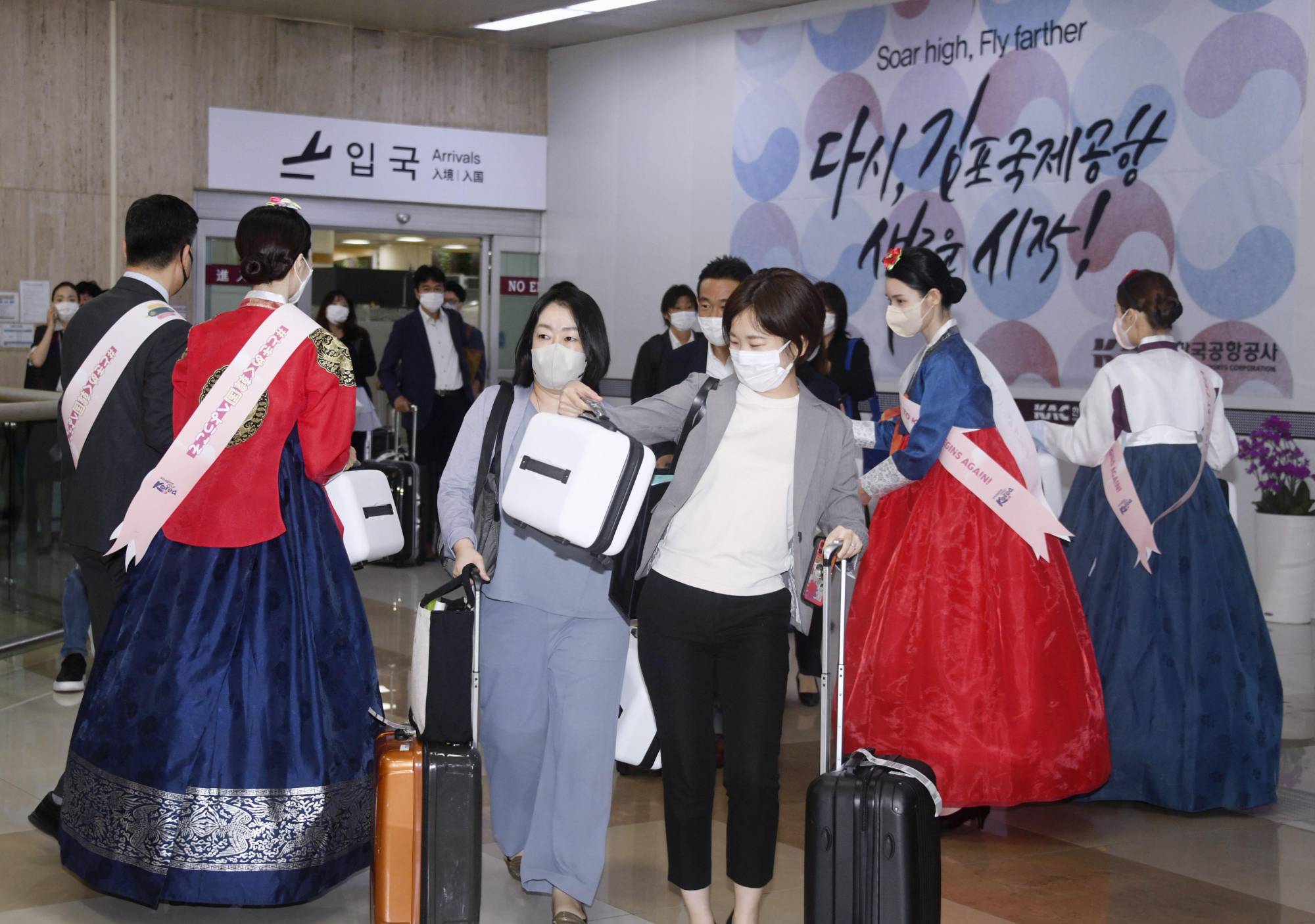 Passengers are welcomed at Seoul's Gimpo Airport after arriving via a freshly resumed flight from Haneda Airport in Tokyo on Wednesday. | KYODO