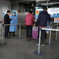 Travelers enter a terminal hall at Beijing Capital International Airport in March. | REUTERS