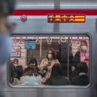 Women ride a subway car in Osaka. Many factors have undoubtedly contributed to Japan’s coronavirus outcomes. But social conformity — and a fear of public shaming that is instilled from the youngest ages — has been a key ingredient in Japan’s relative success in COVID prevention, experts say.  | HIROKO MASUIKE / THE NEW YORK TIMES