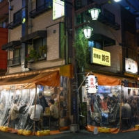 Diners at a restaurant in Tokyo. In Japan, people often policed one another or businesses seen to be violating municipal requests to close early or stop serving alcohol during periods designated as COVID states of emergency. | NORIKO HAYASHI / THE NEW YORK TIMES
