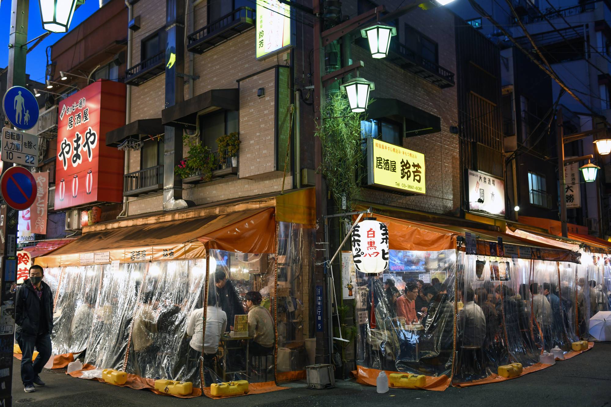 Diners at a restaurant in Tokyo. In Japan, people often policed one another or businesses seen to be violating municipal requests to close early or stop serving alcohol during periods designated as COVID states of emergency. | Noriko Hayashi / The New York Times