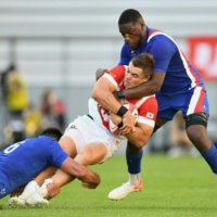 France\'s Dylan Cretin (left) and Yaon Tanga (right) tackle Japan\'s Wimpie van der Walt during an international rugby union test in Toyota, Aichi Prefecture, on Saturday. | AFP-JIJI