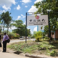 Pedestrians pass a Bank of China sign in Lusaka, Zambia. | BLOOMBERG