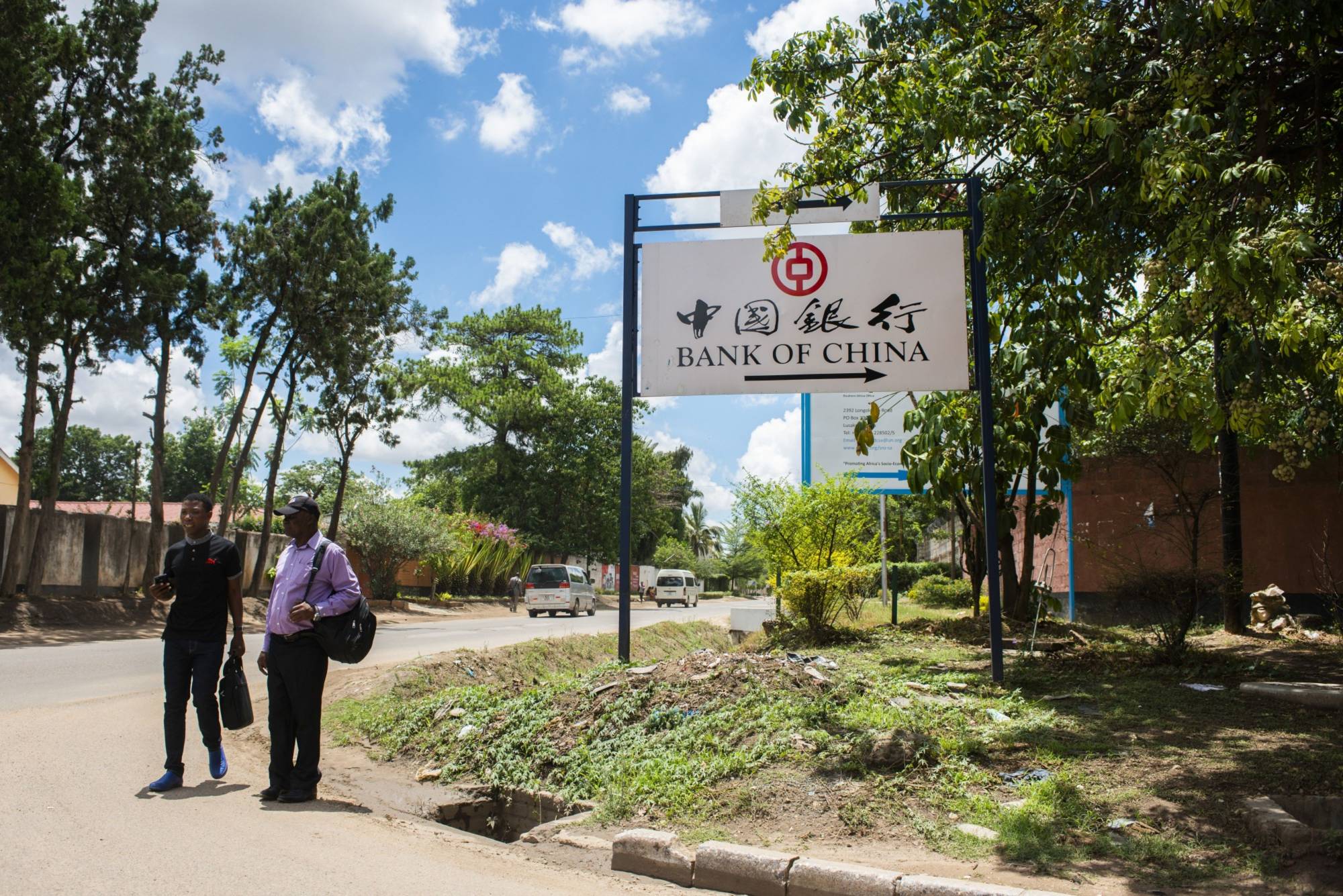Pedestrians pass a Bank of China sign in Lusaka, Zambia. | BLOOMBERG