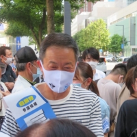 LDP candidate Gaku Hasegawa meets and greets supporters just before an appearance with Kishida on Sunday. | ERIC JOHNSTON
