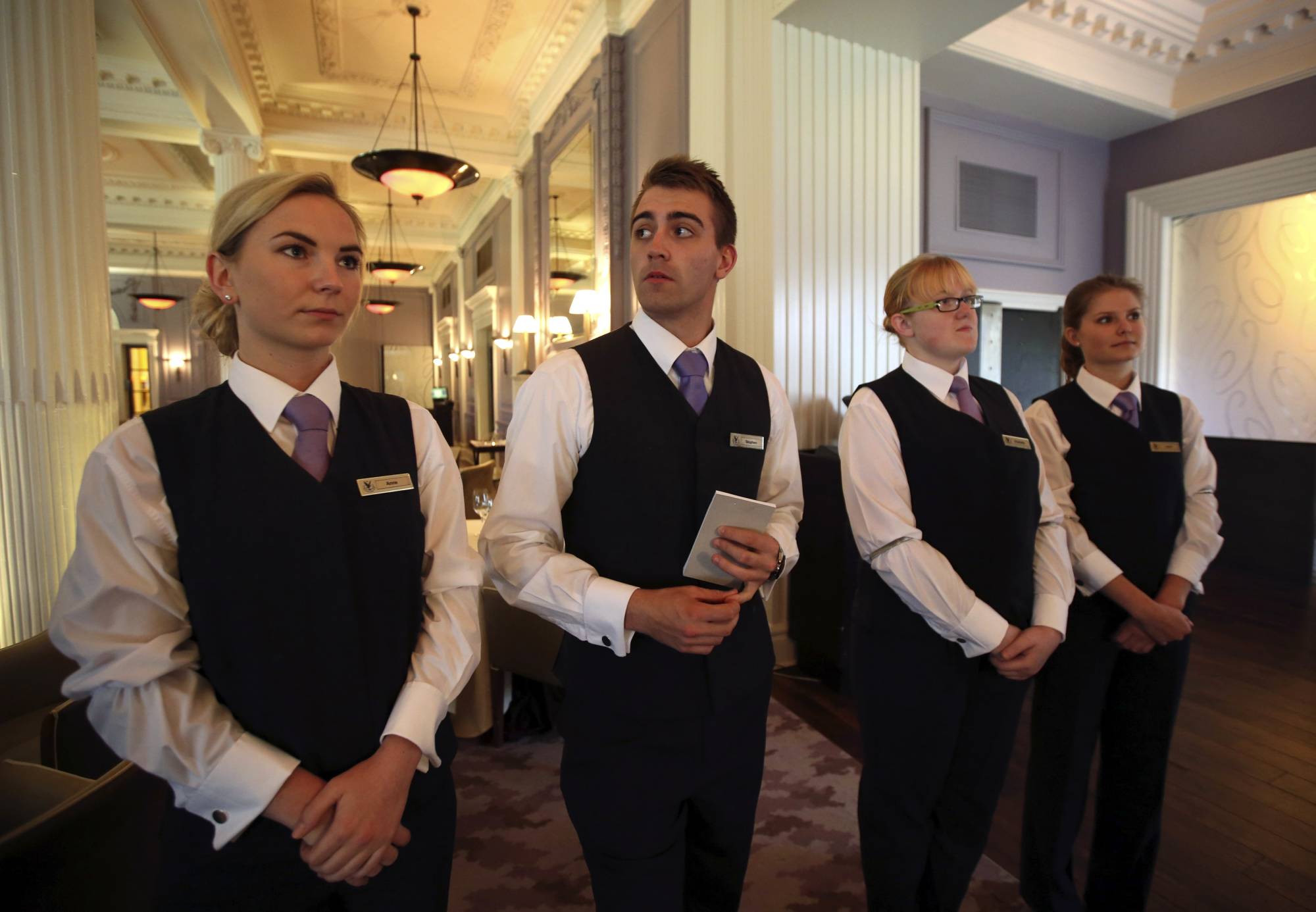 Waitstaff gather for a meeting before starting service at Scotland's Gleneagles Hotel in 2014. | REUTERS