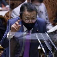 Former Prime Minister Taro Aso has drawn criticism for likening the Russian invasion of Ukraine to the bullying of weak children. | BLOOMBERG