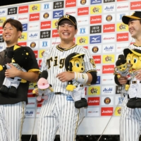 Tigers players (from left) Yuki Nishi, Fumiya Hojo and Yasuhiro Yamamoto participate in the hero interview following the team\'s win over the Carp at Koshien Stadium on Wednesday. | KYODO