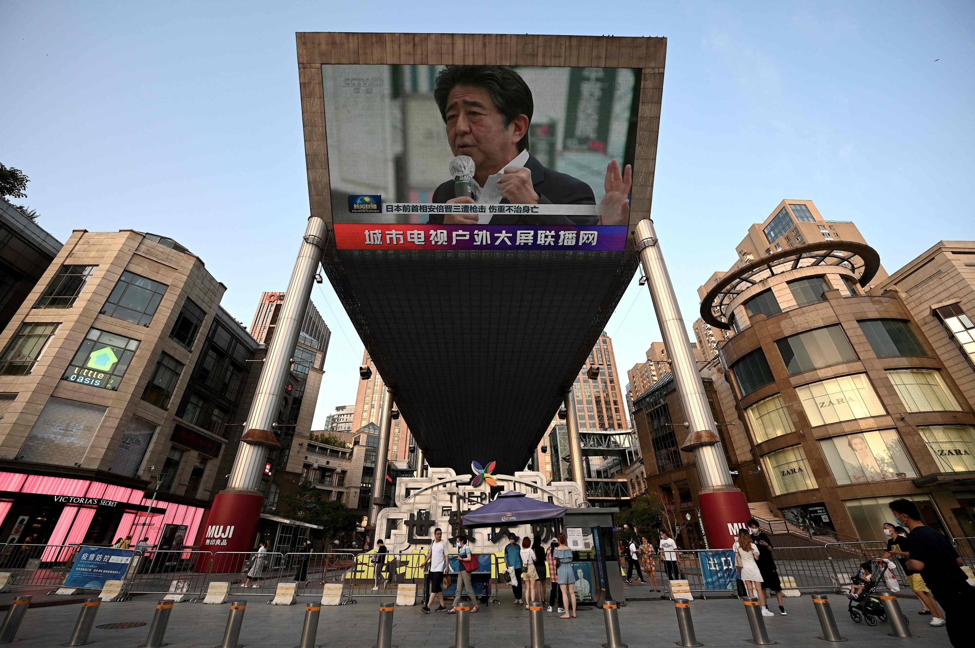 A large video screen shows news broadcast featuring an image of Abe in Beijing on Friday. | AFP-JIJI