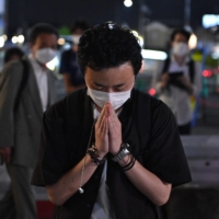 A man prays on Friday evening near Yamato-Saidaiji Station in Nara where Abe was shot earlier in the day. | AFP-JIJI
