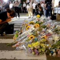 A woman prays at the site were Abe was shot while campaigning for the upcoming upper house election. | REUTERS