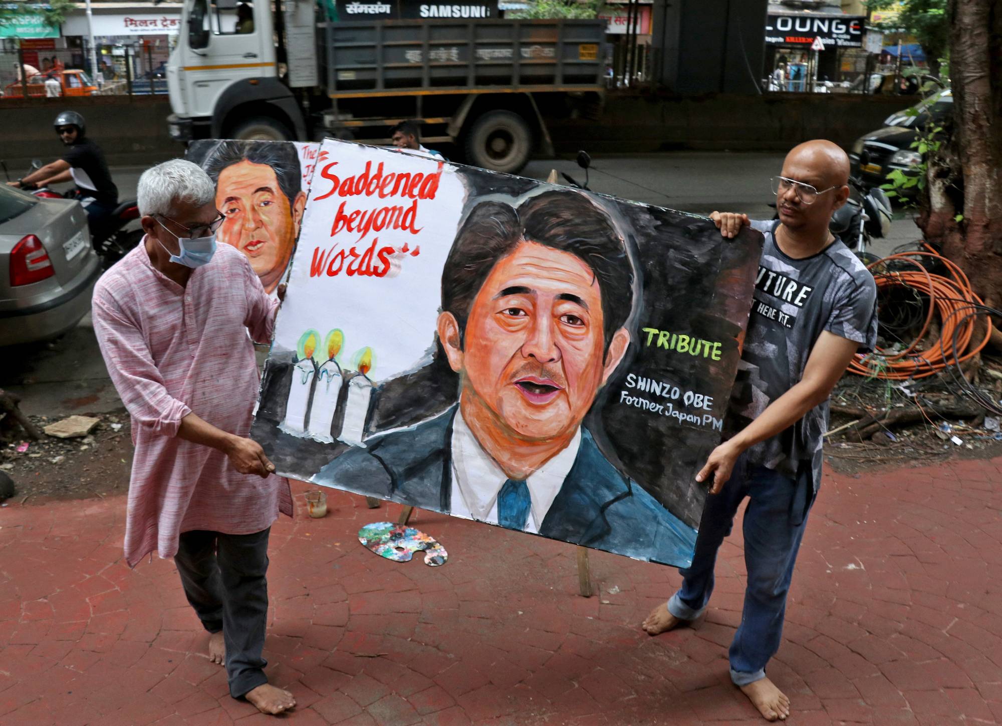 Artists display a memorial painting of Abe, outside an art school in Mumbai on Friday. | REUTERS