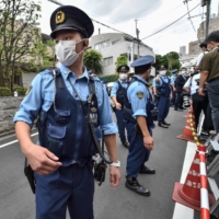 Police gather on the street outside the residence of the late former Prime Minister Shinzo Abe in Tokyo on Saturday, a day after he was assassinated — an especially shocking incident given the country\'s strict gun laws and low rates of violent crime. | AFP-JIJI