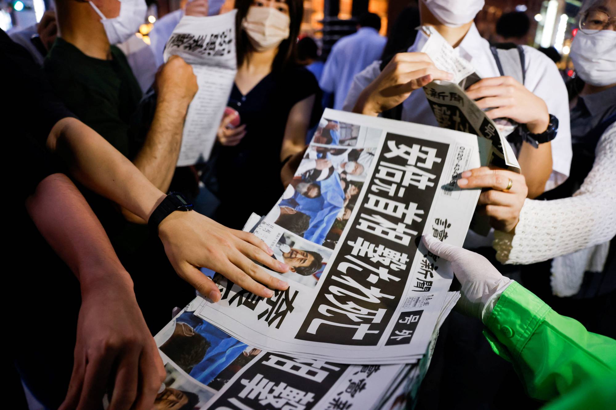 An extra edition of the Yomiuri Shimbun newspaper reporting on the death of former Prime Minister Shinzo Abe is handed out in Tokyo on Friday. | REUTERS