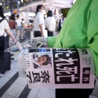 Copies of an extra edition of the Yomiuri Shimbun newspaper are distributed in Tokyo on Friday . | BLOOMBERG